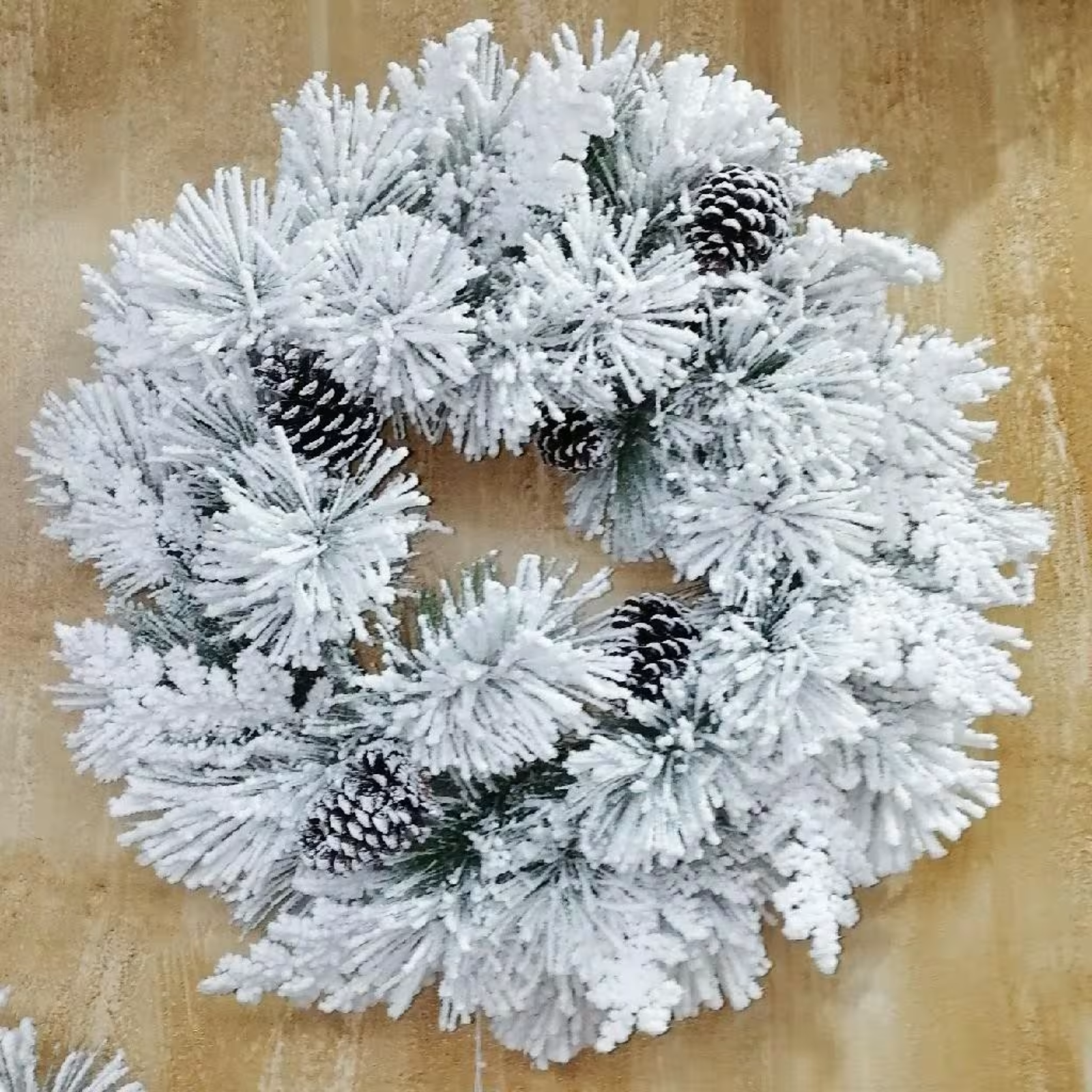 Ghirlanda dietro porta innevata con pigne decorazione natalizie